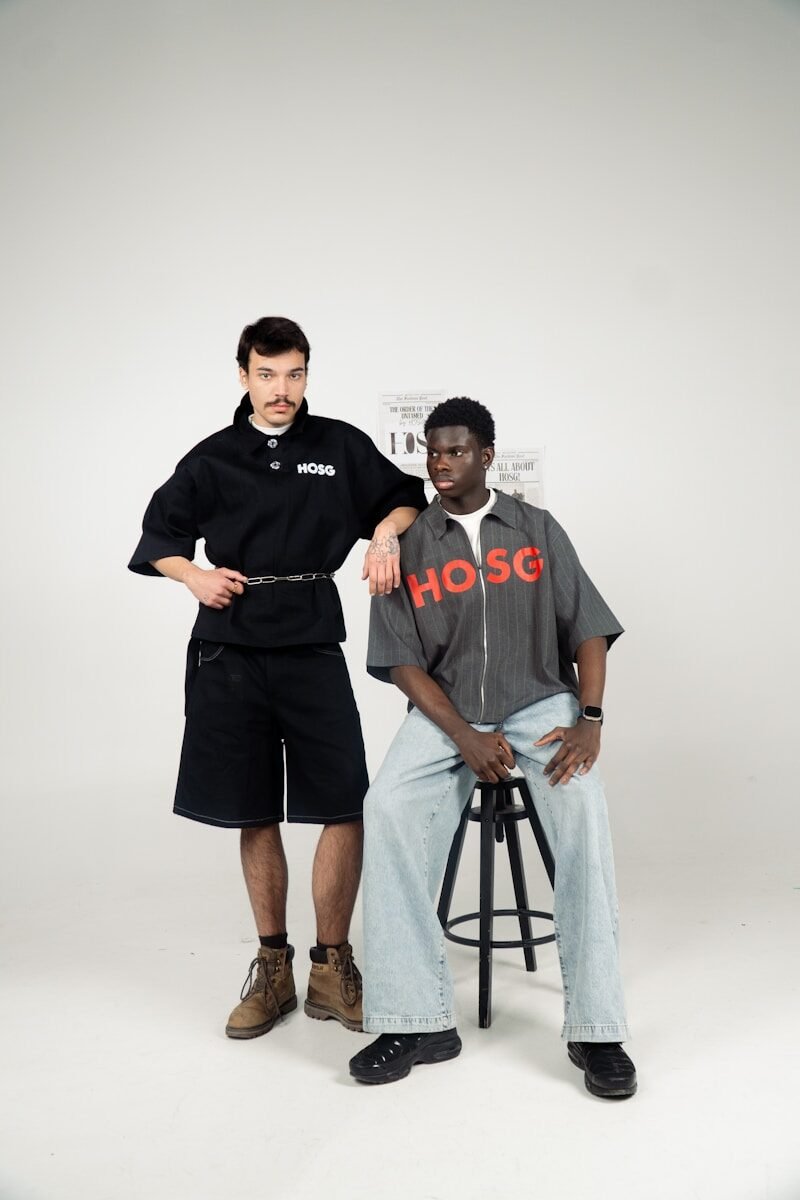 Two men posing in stylish streetwear on a white background.